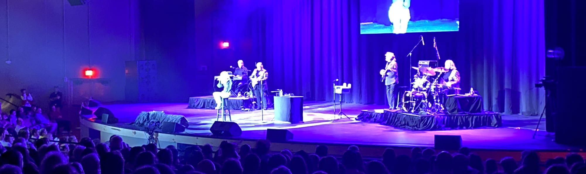 signer on stage in chair washed out by the lights Pensacola
